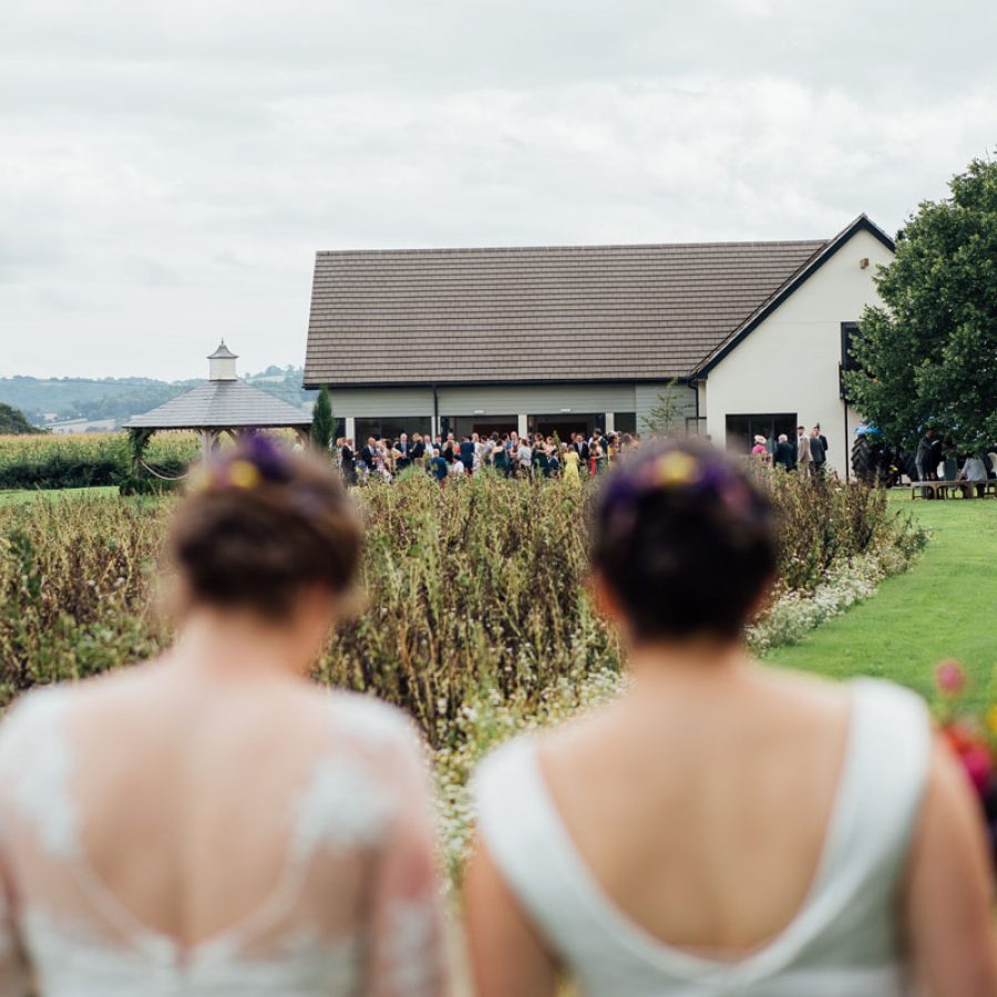 Two brides approaching Harefield Barn Wedding Venue in Devon